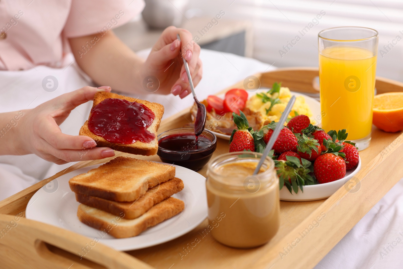 Photo of Woman having tasty breakfast in bed, closeup