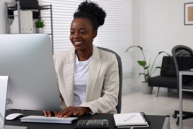 Professional accountant working on computer at desk in office. Space for text