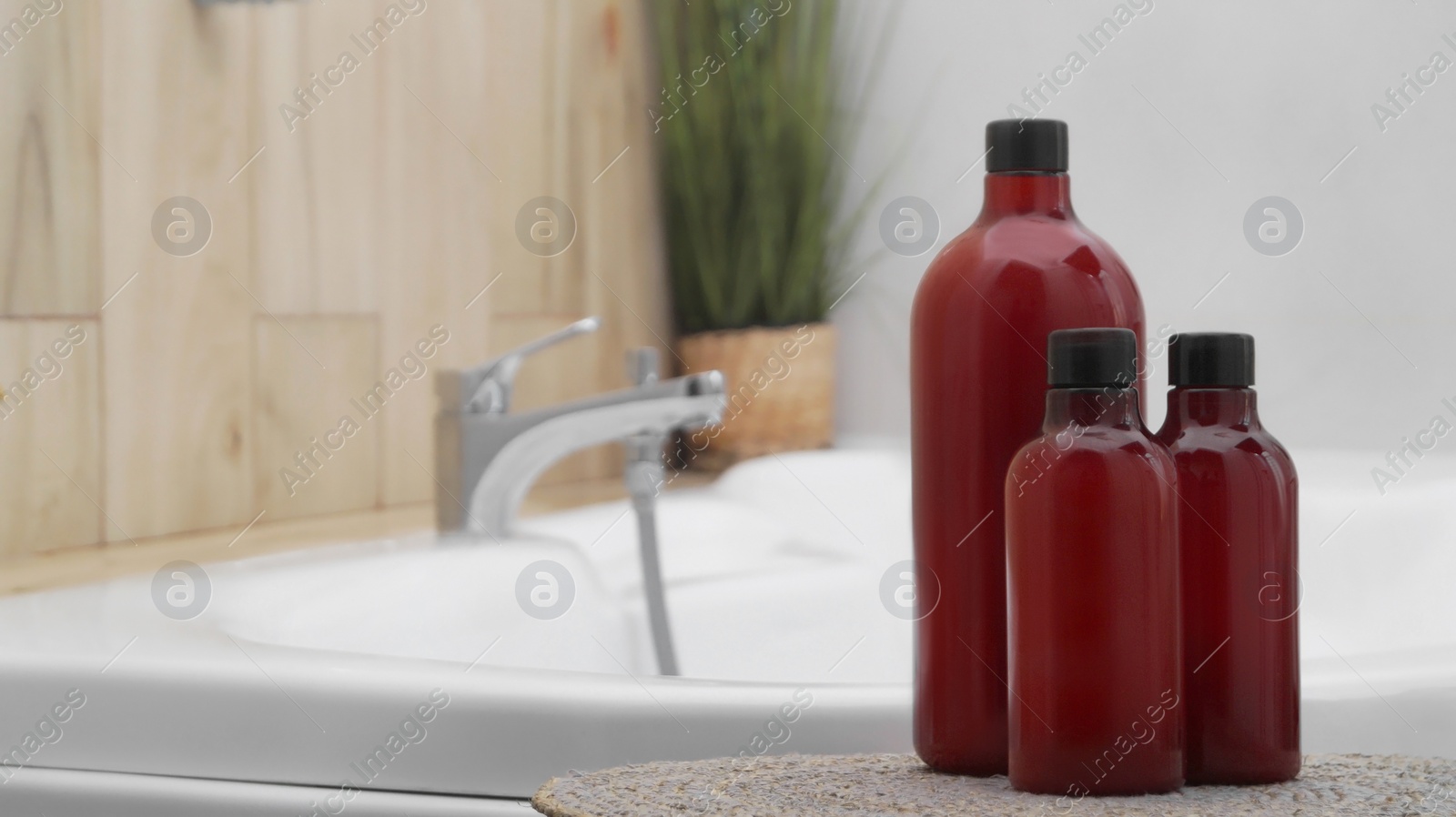 Photo of Bath foam and other personal hygiene products in bottles on wicker mat in bathroom, space for text