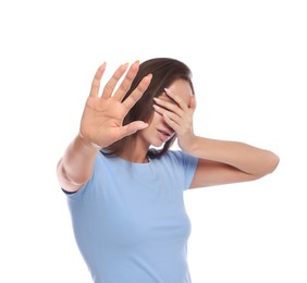 Photo of Embarrassed woman covering face against white background, focus on hand