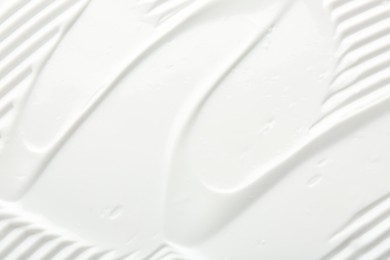 Photo of Texture of face care cream as background, top view