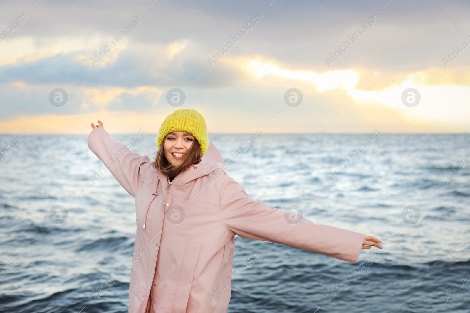 Photo of Stylish young woman spending time near sea