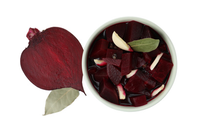 Pickled beets with garlic in bowl on white background, top view