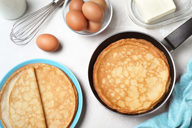 Flat lay composition with thin pancakes on grey marble table