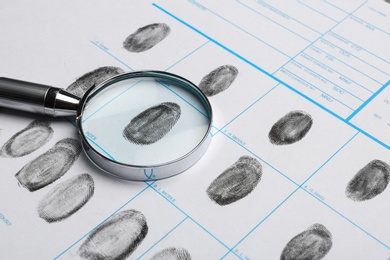 Magnifying glass and criminal fingerprint card, closeup