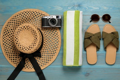 Different beach objects on light blue wooden background, flat lay