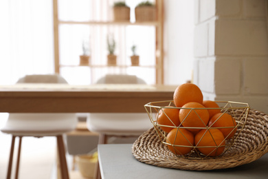 Photo of Fresh ripe oranges on countertop in kitchen. Space for text