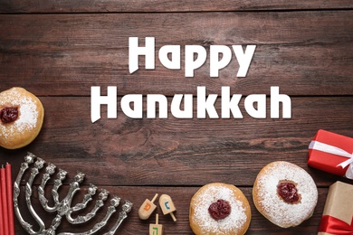 Image of Happy Hanukkah. Traditional menorah, candles, sufganiyot and dreidels on wooden background, flat lay 