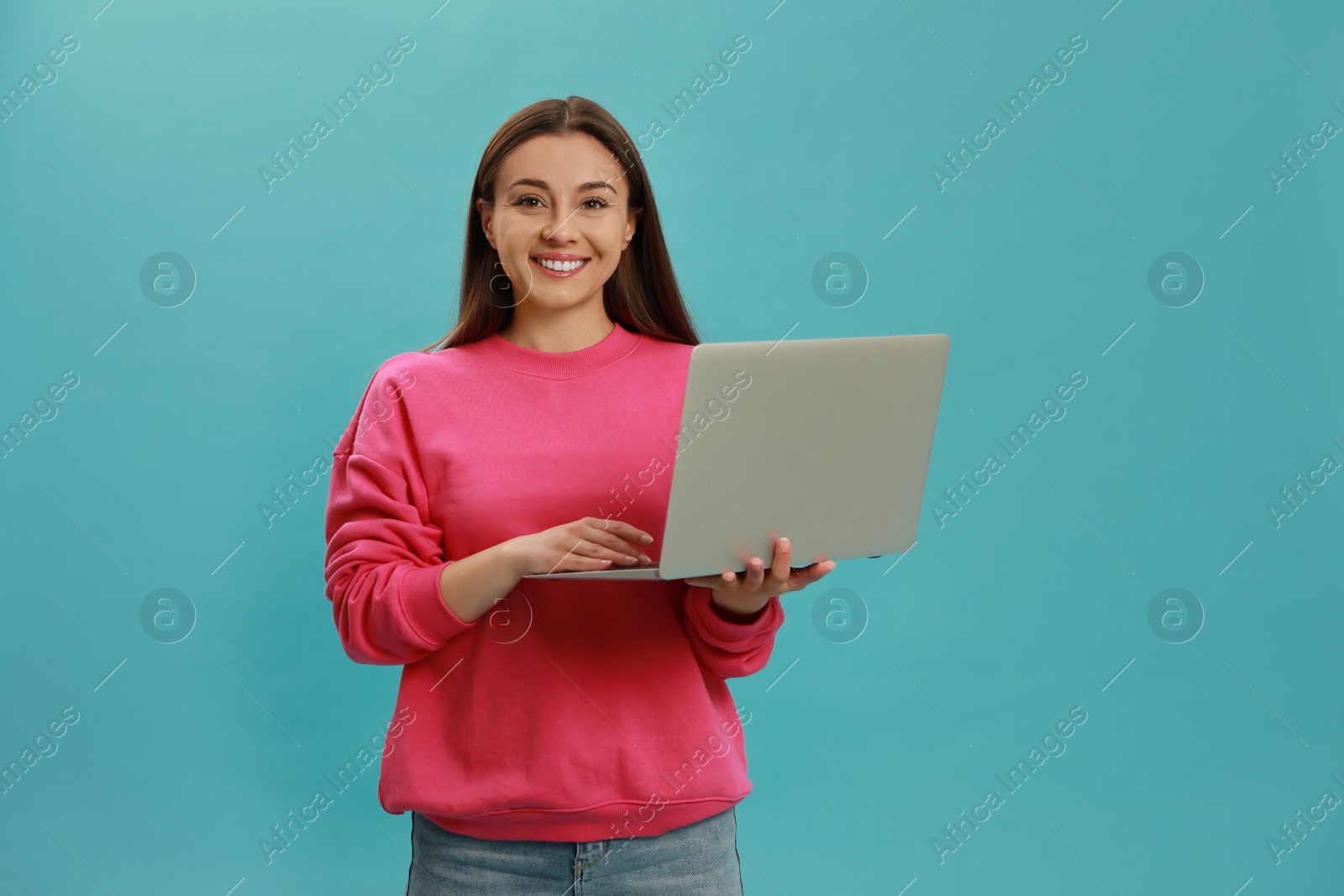 Photo of Young woman with modern laptop on light blue background