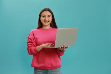 Photo of Young woman with modern laptop on light blue background