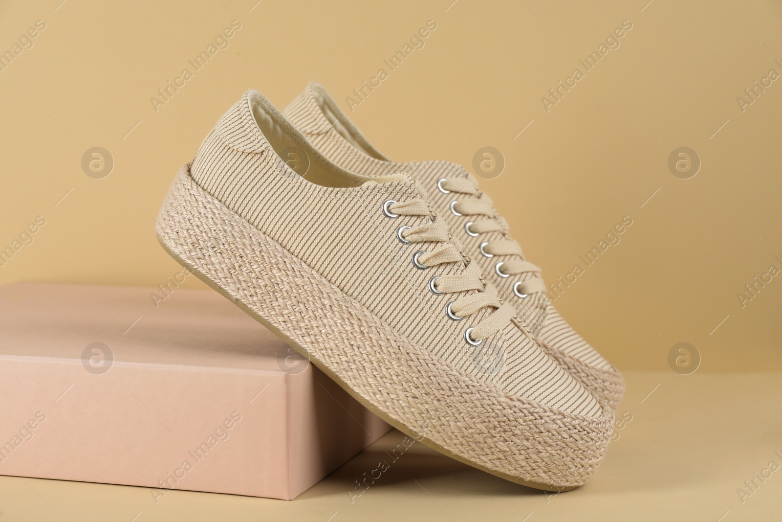 Photo of Pair of stylish sneakers on beige background