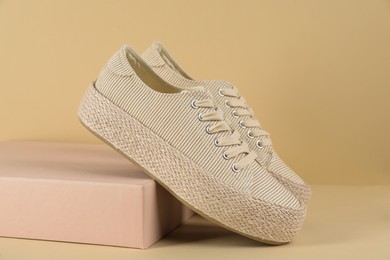 Photo of Pair of stylish sneakers on beige background