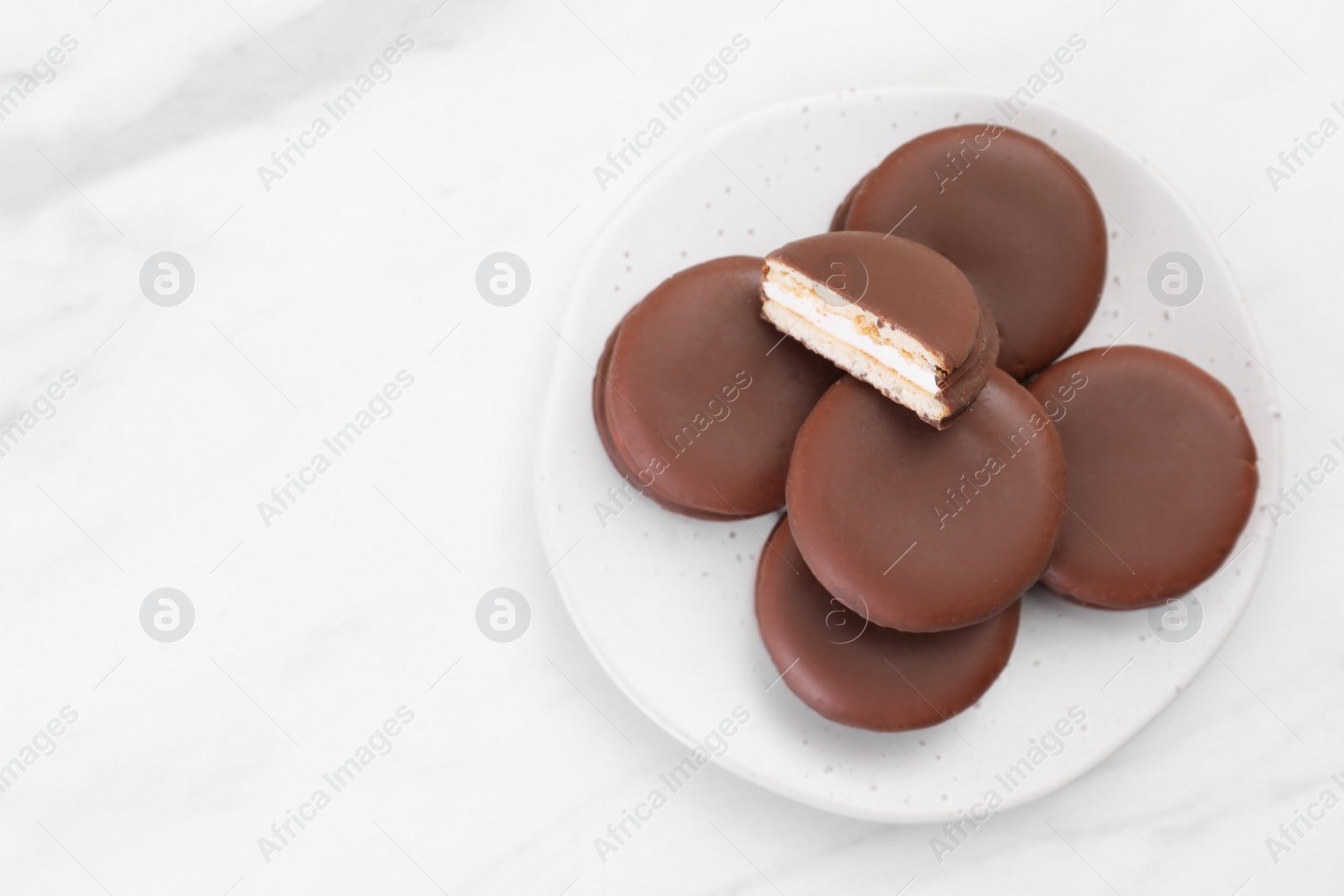 Photo of Saucer with delicious choco pies on white table, top view. space for text