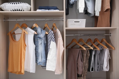 Photo of Collection of stylish clothes in large wardrobe closet