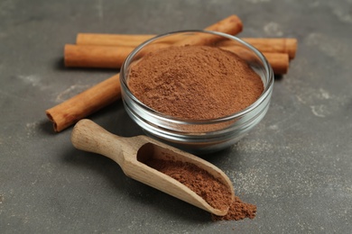 Photo of Cinnamon sticks and powder on grey table