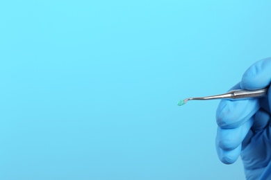 Photo of Dentist holding professional instrument on color background, space for text. Mouth and teeth care
