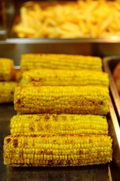 Photo of Delicious grilled corn cobs on table. Street food