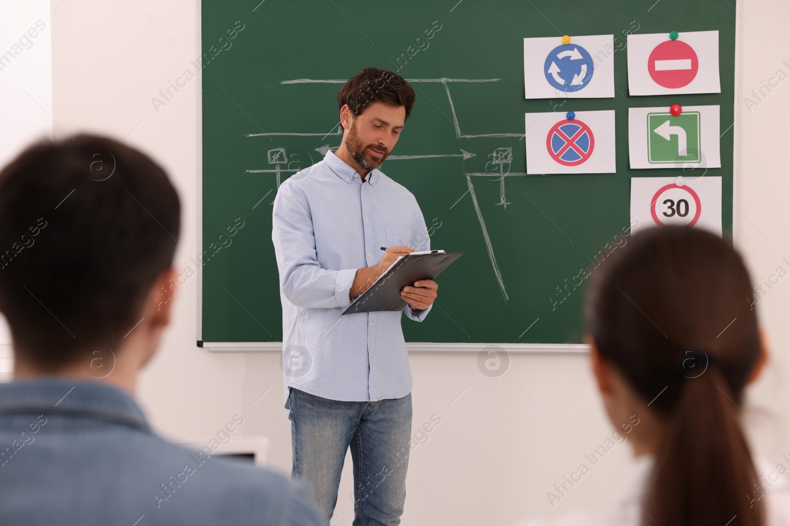 Photo of Teacher giving lesson to audience in driving school