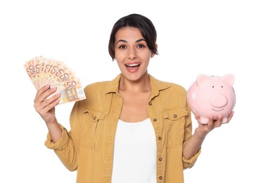 Photo of Excited young woman with money and piggy bank on white background