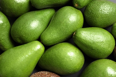 Photo of Many ripe fresh avocados as background