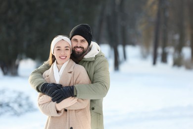 Photo of Beautiful young couple enjoying winter day outdoors. Space for text