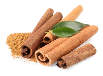 Dry aromatic cinnamon sticks, powder and green leaves isolated on white