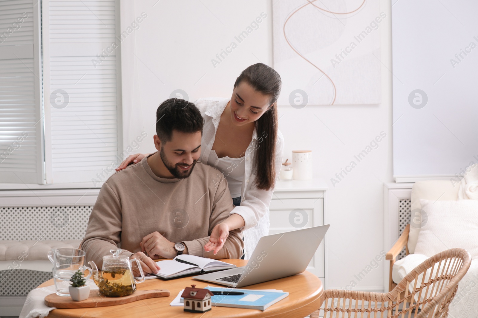 Photo of Happy young couple discussing family budget and new house buying at home. Mortgage concept