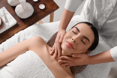 Photo of Young woman enjoying professional massage in spa salon, above view