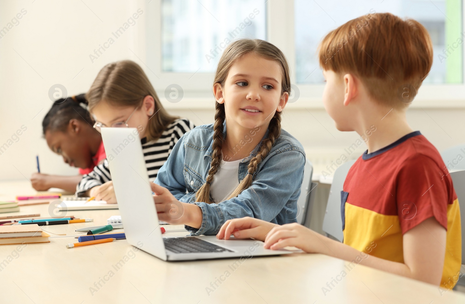 Photo of Cute children studying in classroom at school