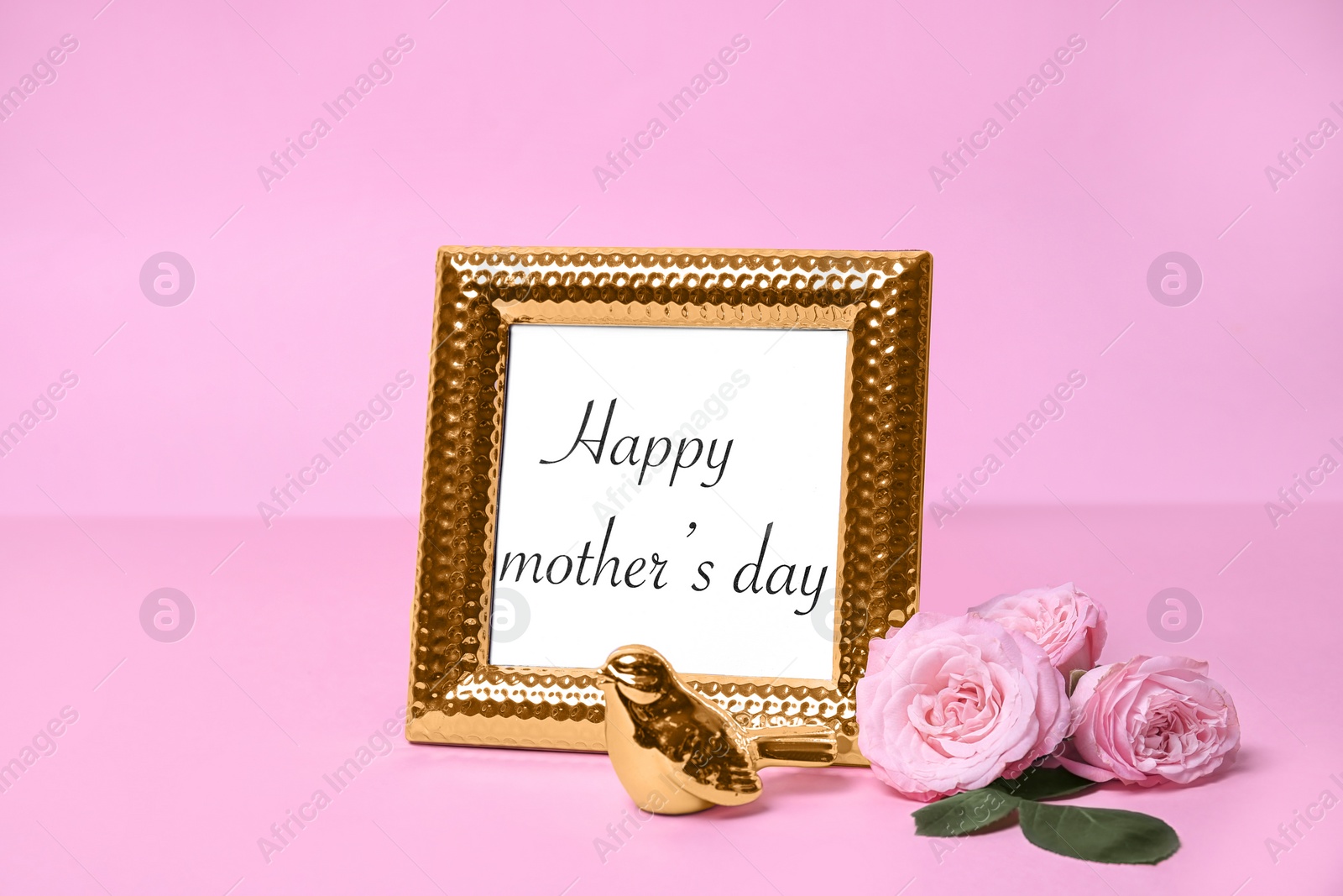 Photo of Greeting card with phrase "HAPPY MOTHER'S DAY" in frame and flowers on color background