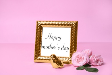 Greeting card with phrase "HAPPY MOTHER'S DAY" in frame and flowers on color background