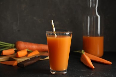 Photo of Glass of freshly made carrot juice on black table