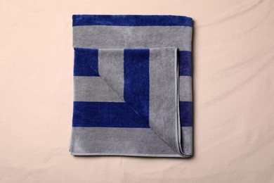 Photo of Striped beach towel on sand, top view
