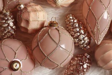 Photo of Collection of beautiful Christmas tree baubles on white faux fur, closeup