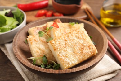 Photo of Delicious turnip cake with microgreens on wooden table, closeup