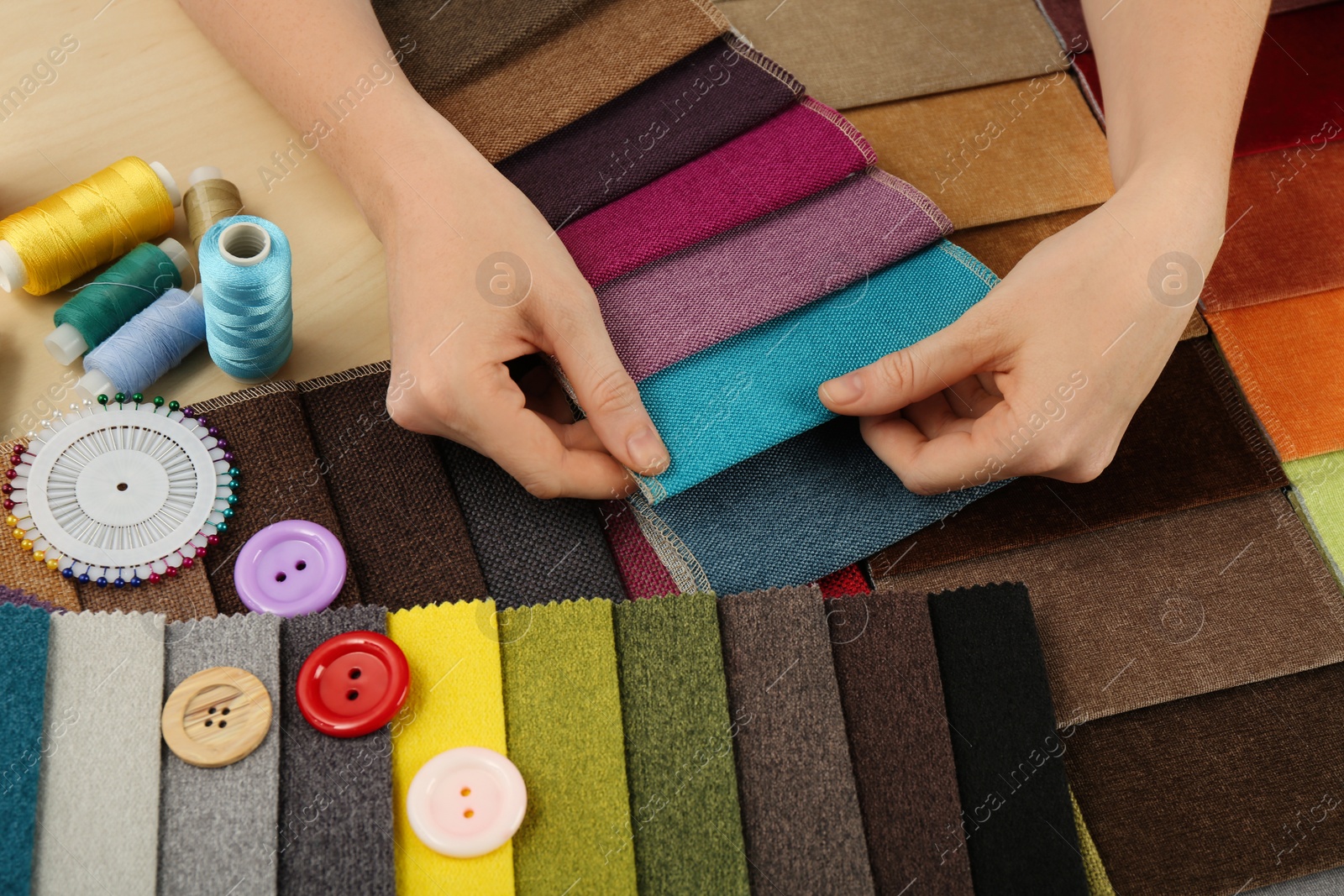 Photo of Woman choosing among colorful fabric samples, closeup