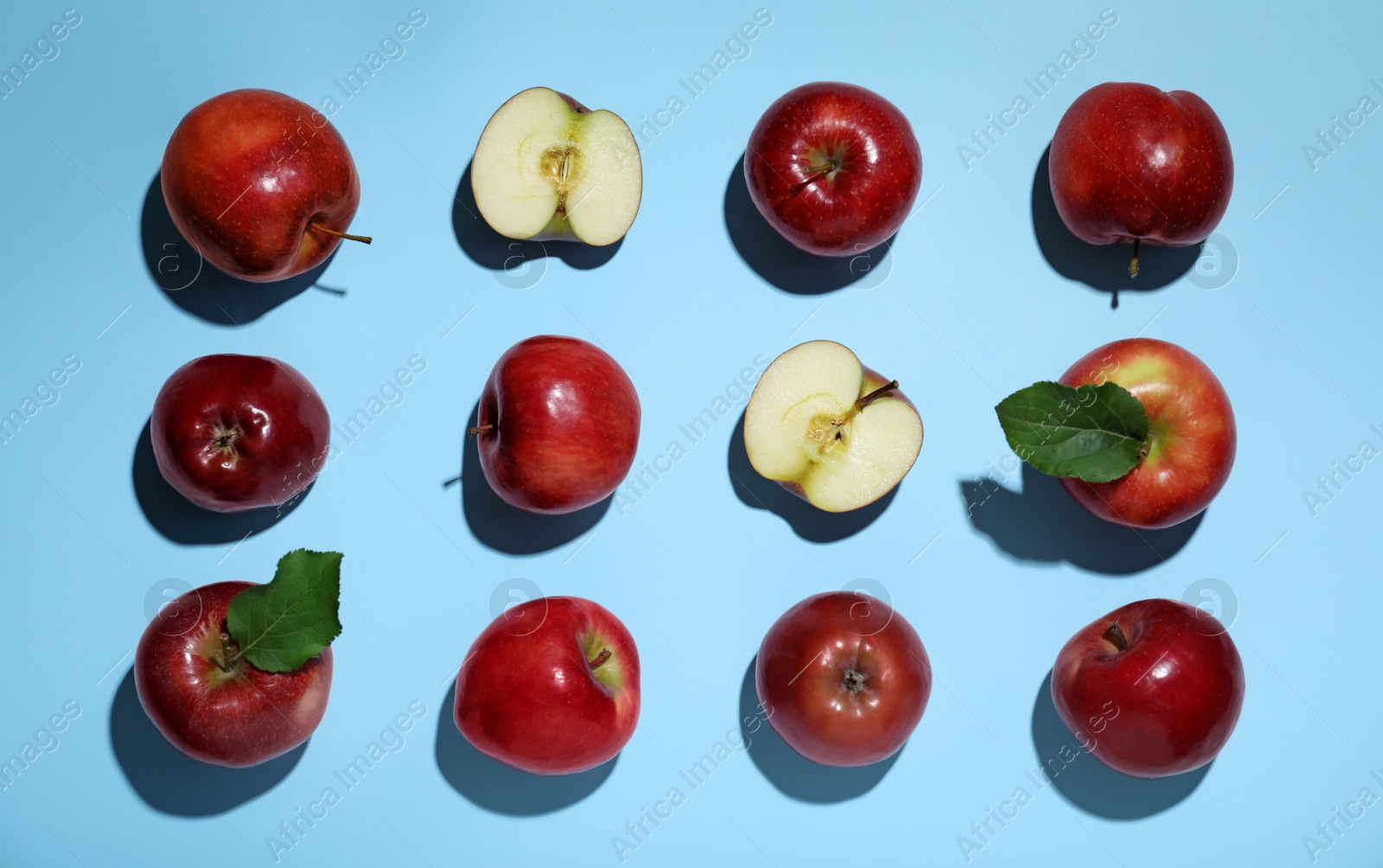 Photo of Tasty red apples on light blue background, flat lay