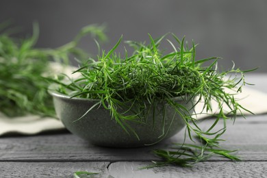 Photo of Fresh tarragon leaves on grey wooden table