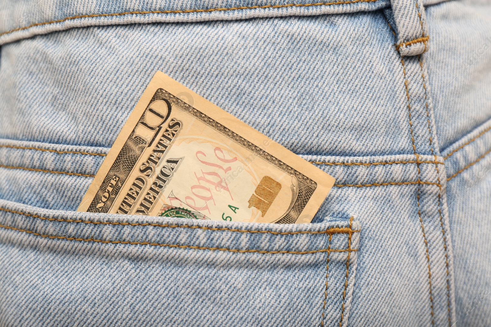 Photo of Dollar banknote in pocket of jeans, closeup. Spending money