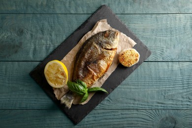 Delicious dorado fish served on wooden table, top view