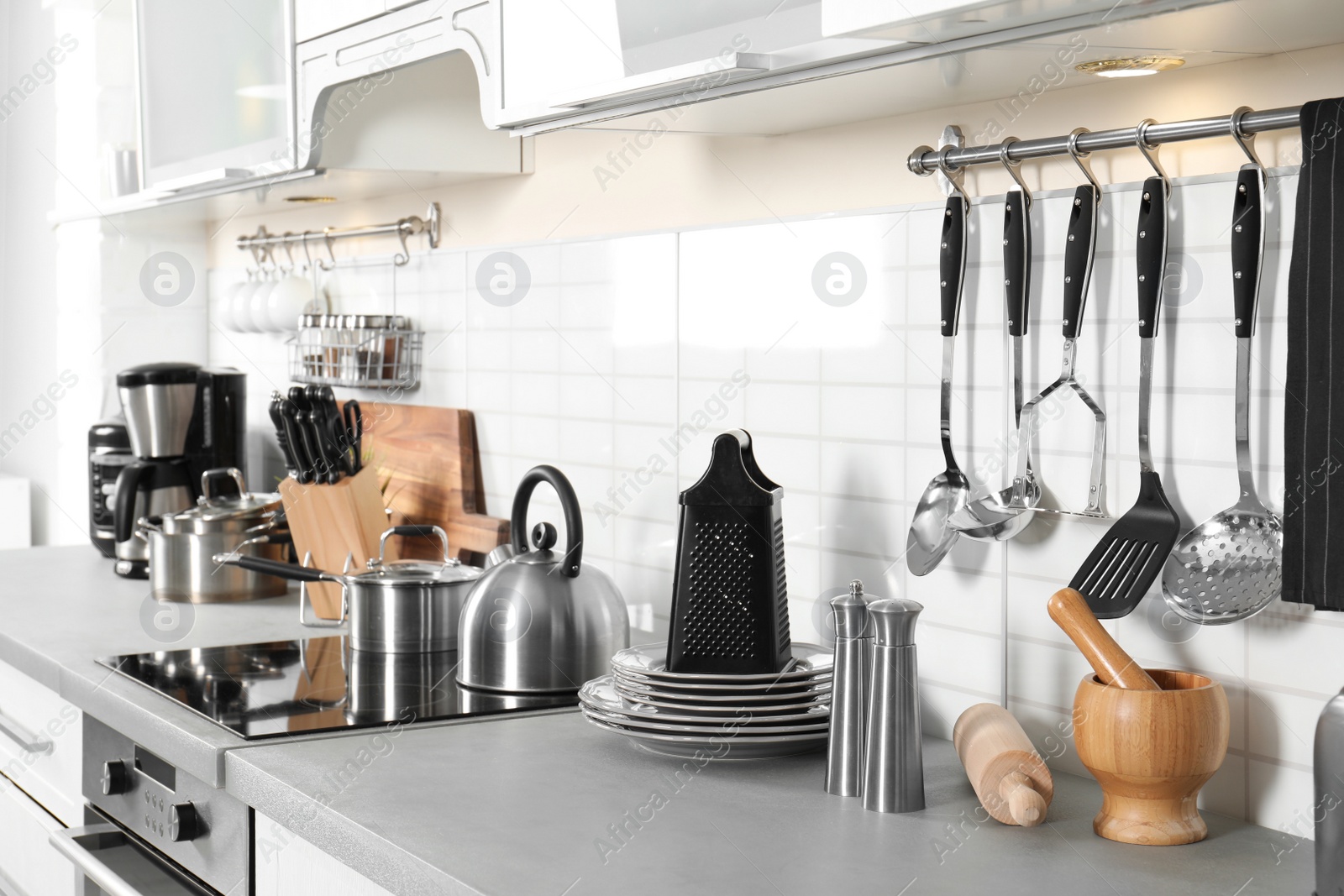 Photo of Different appliances, clean dishes and utensils on kitchen counter