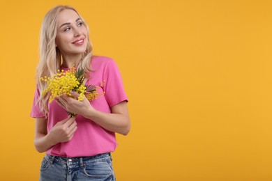 Photo of Happy young woman with beautiful bouquet on orange background. Space for text