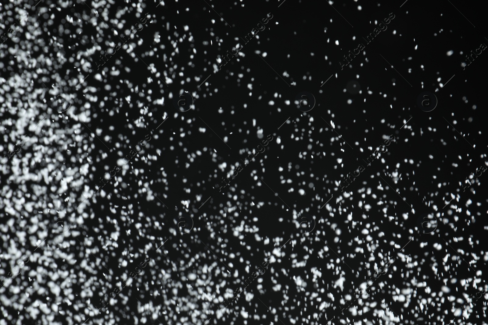 Photo of White snow falling down on black background