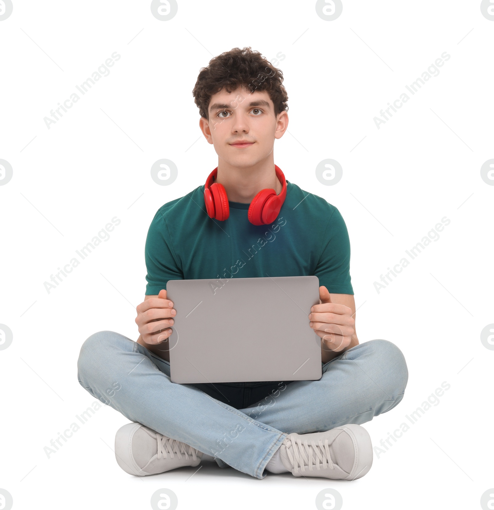 Photo of Portrait of student with laptop and headphones sitting on white background