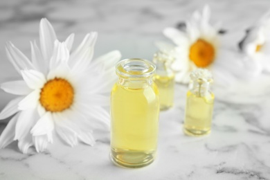 Photo of Composition with essential oil and flowers on table