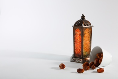 Photo of Muslim lamp and dates on white background. Space for text