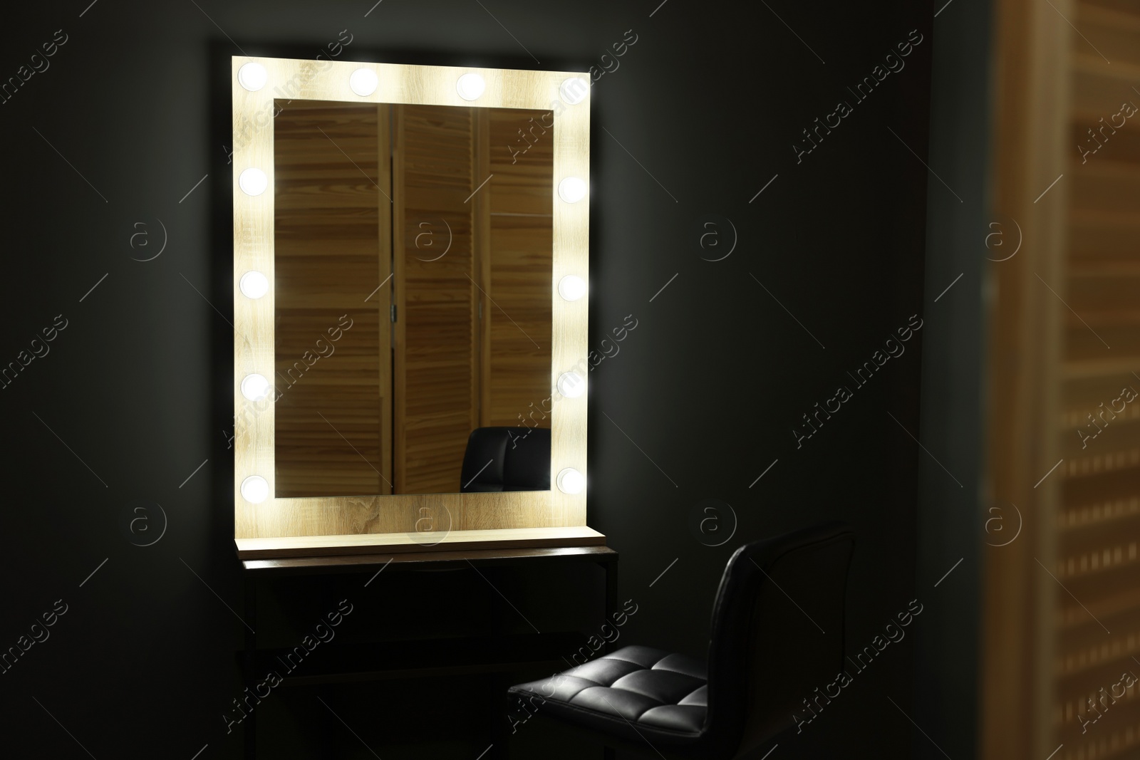 Photo of Beautiful mirror with light bulbs and chair in makeup room