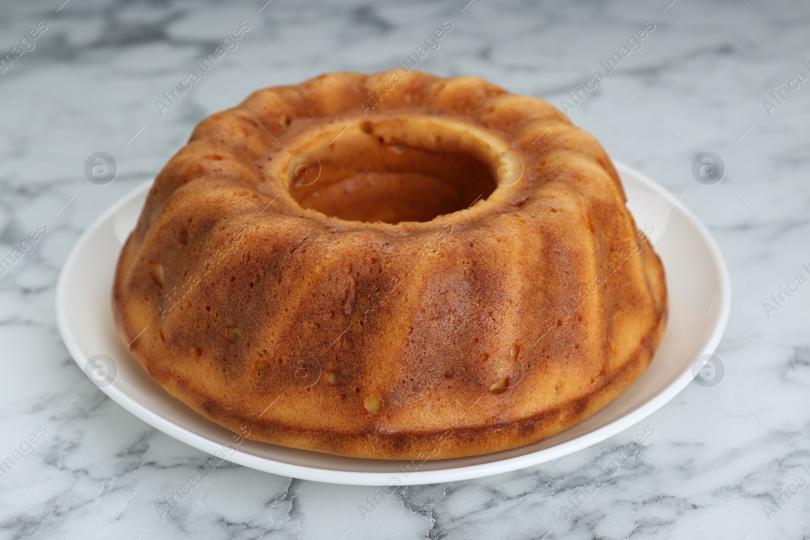 Photo of Homemade yogurt cake on white marble table