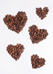 Hearts made of roasted coffee beans on white background