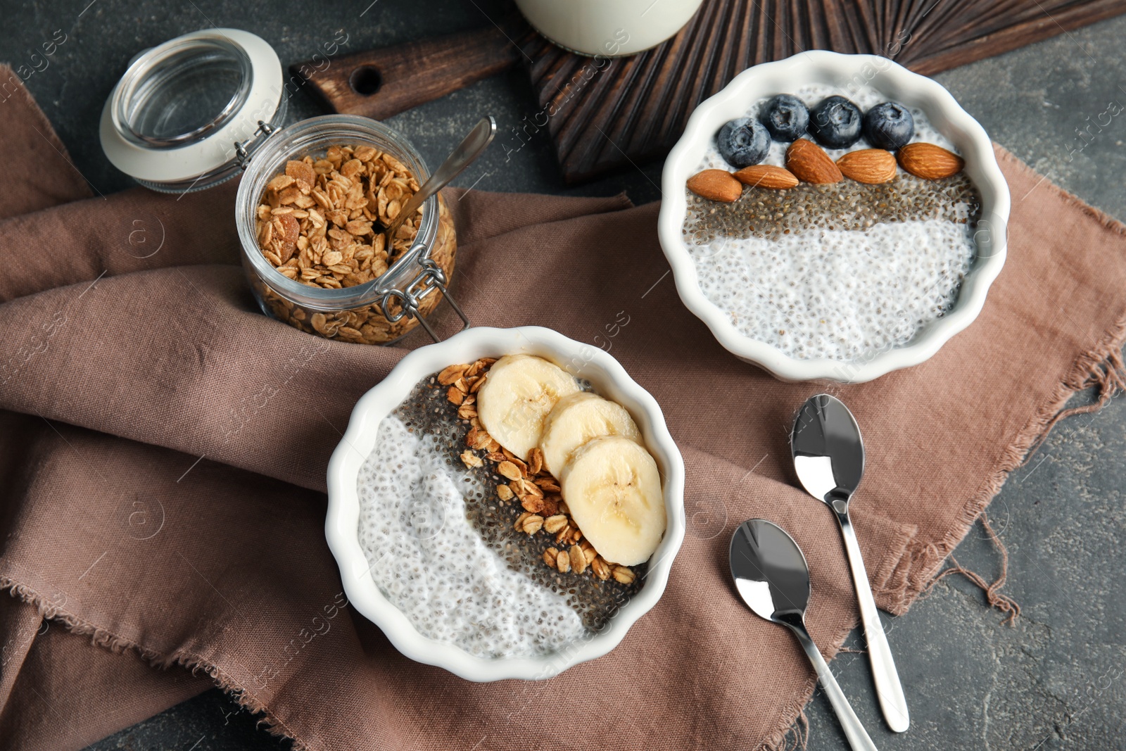 Photo of Tasty chia seed pudding with banana and granola served on table, flat lay